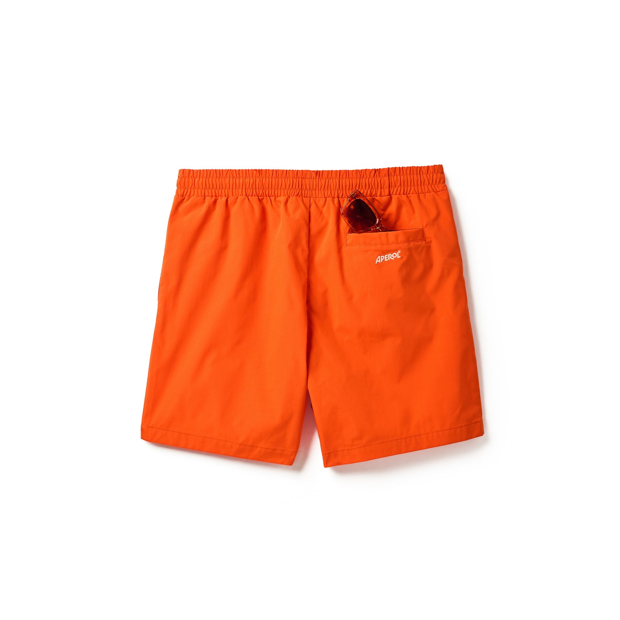 Bright orange swim shorts with an elastic waistband, a side pocket, and a small white APEROL logo on the pocket, shown against a plain white background.