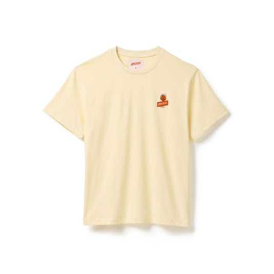 A pale yellow crewneck t-shirt with a small orange and white graphic on the left chest, displayed flat against a white background.