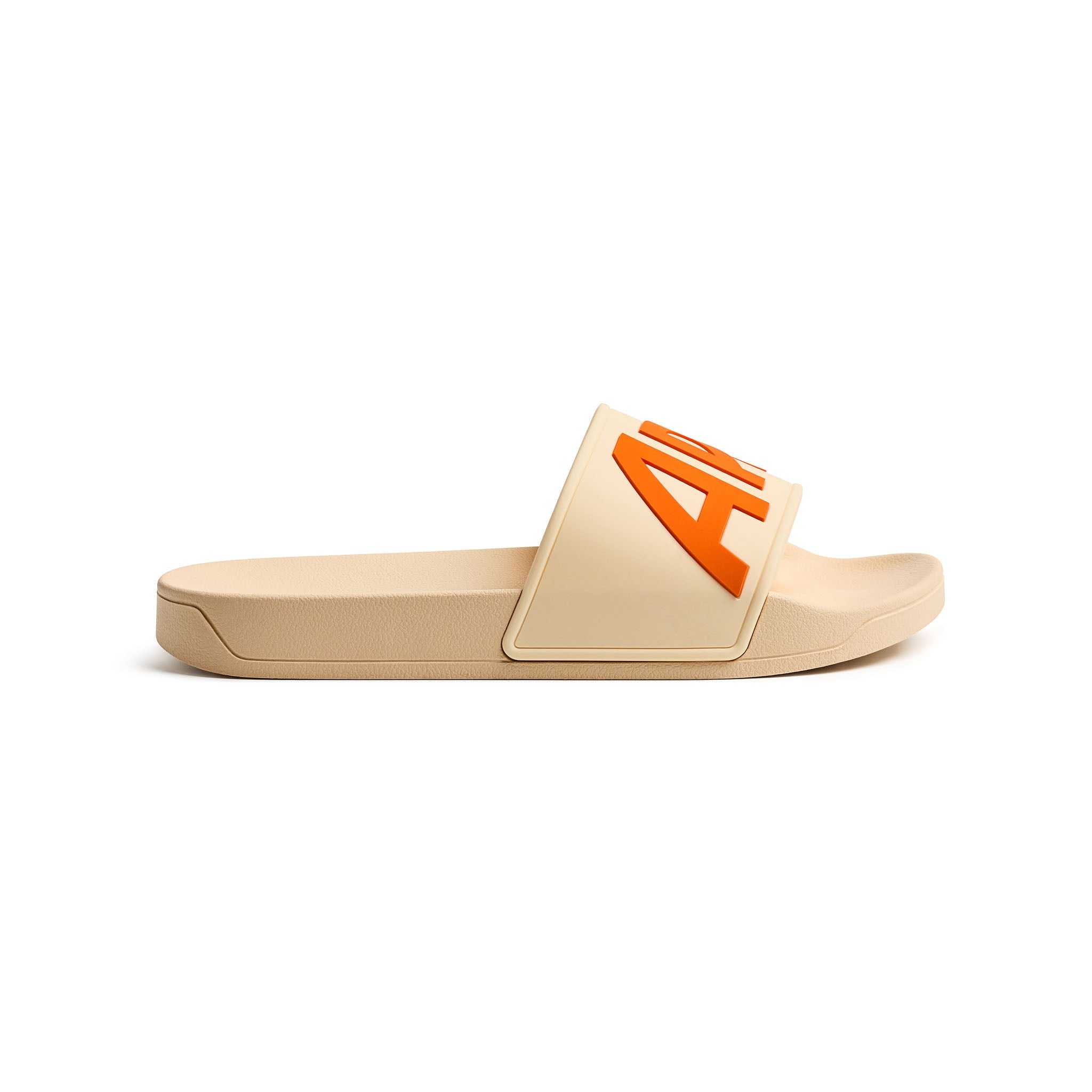 A single slide sandal in beige with a prominent orange logo on the strap, shown from a side profile against a white background.