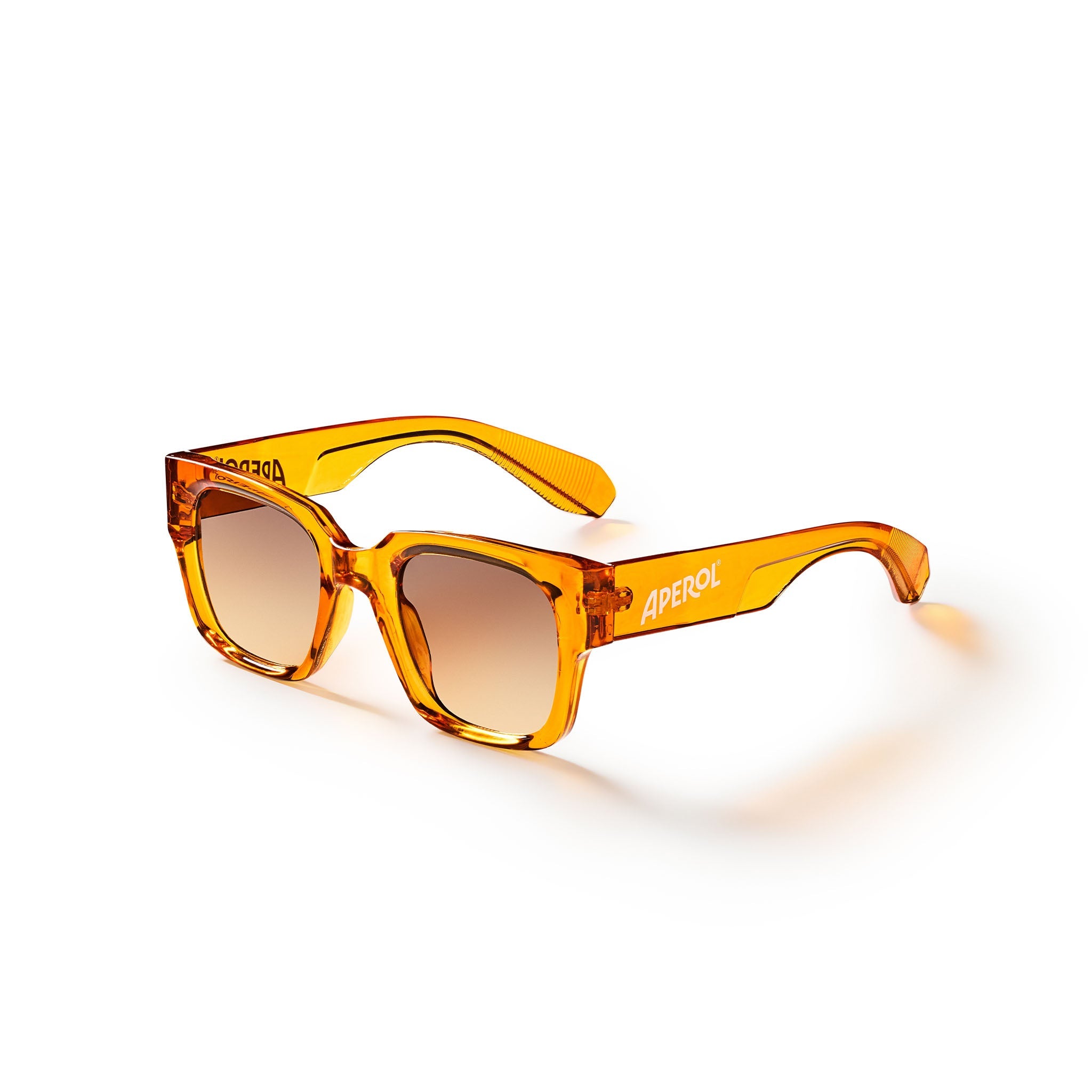 A pair of square-frame sunglasses with translucent amber-orange frames and gradient brown lenses, featuring the brand name 'APEROL' printed on the side of the temple, set against a clean white background.